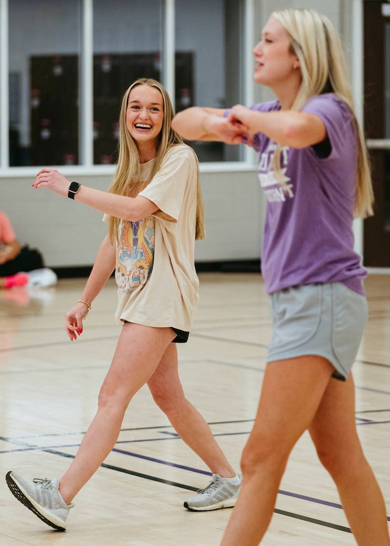 Two students in a fitness class laughing.