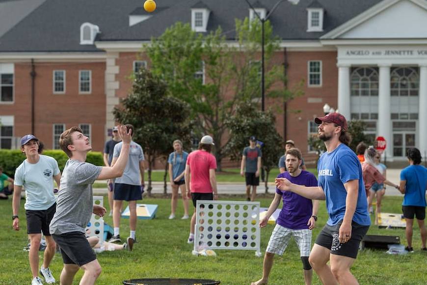 Students playing Slam Ball on the green space in front of the Volpe Libary.