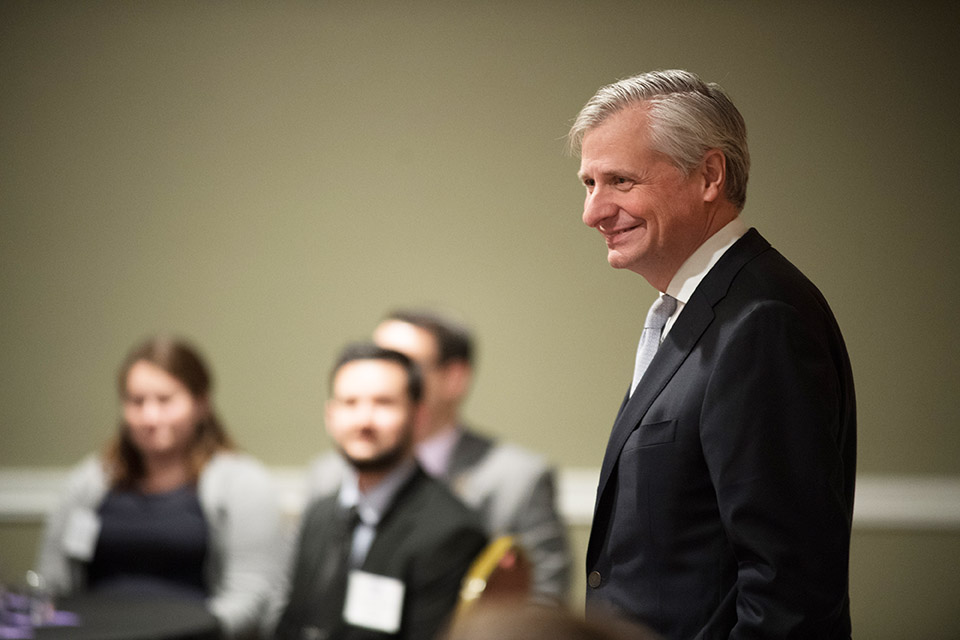 Jon Meacham smiles as he stands in front of a podium.