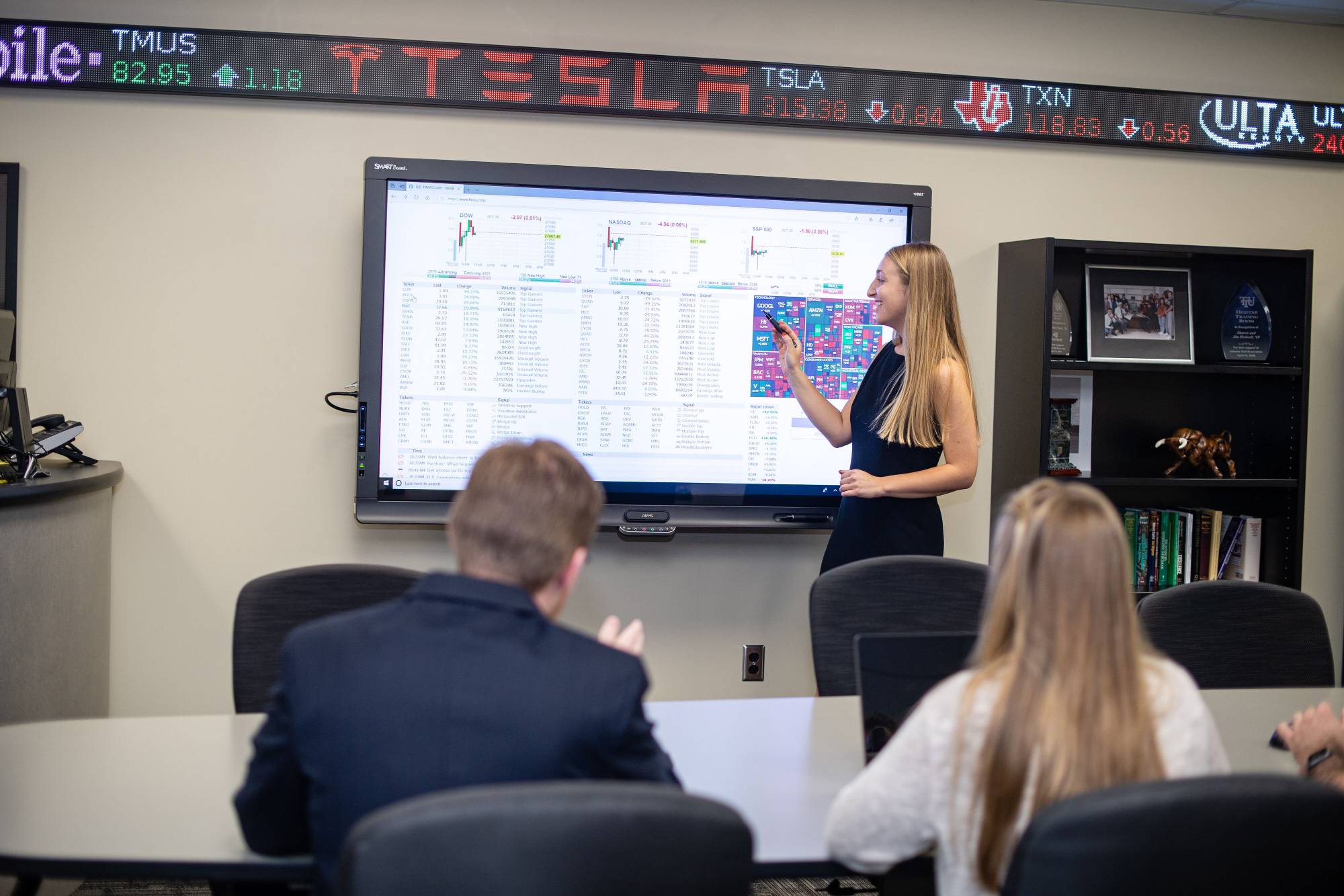 female student giving a presentation in front of a large interactive screen