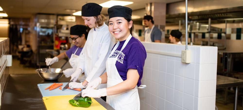 Students prepare a meal in the Friday Cafe Kitchen.
