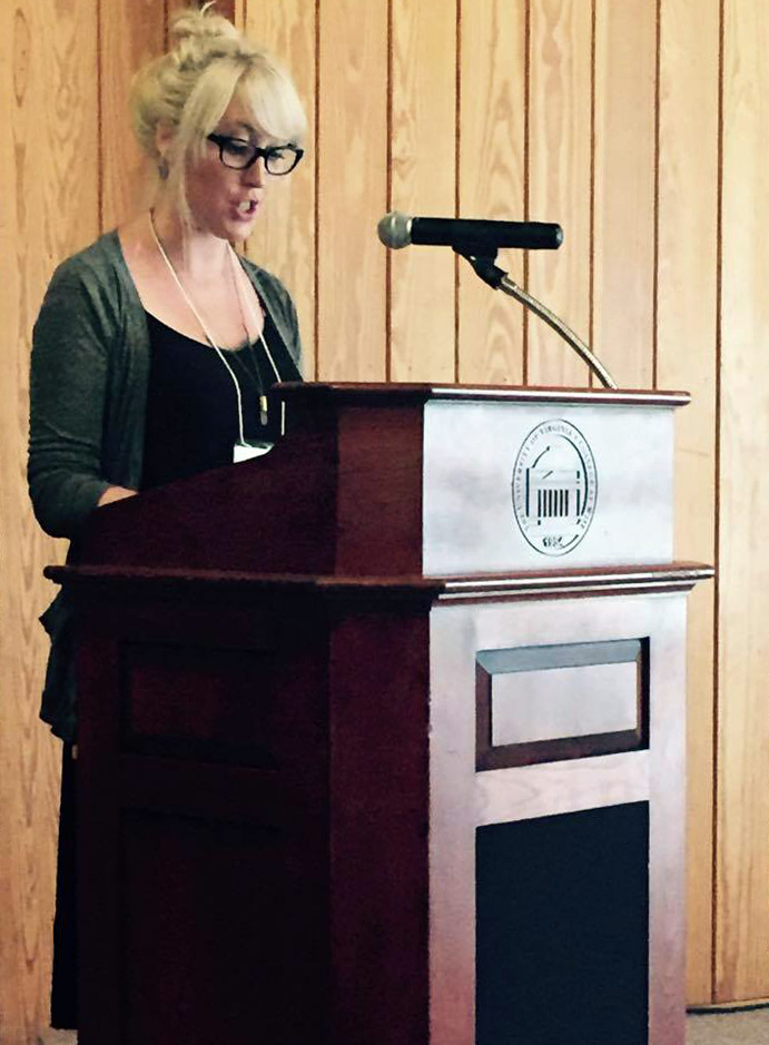 Photograph of a scholar presenting her work at a podium