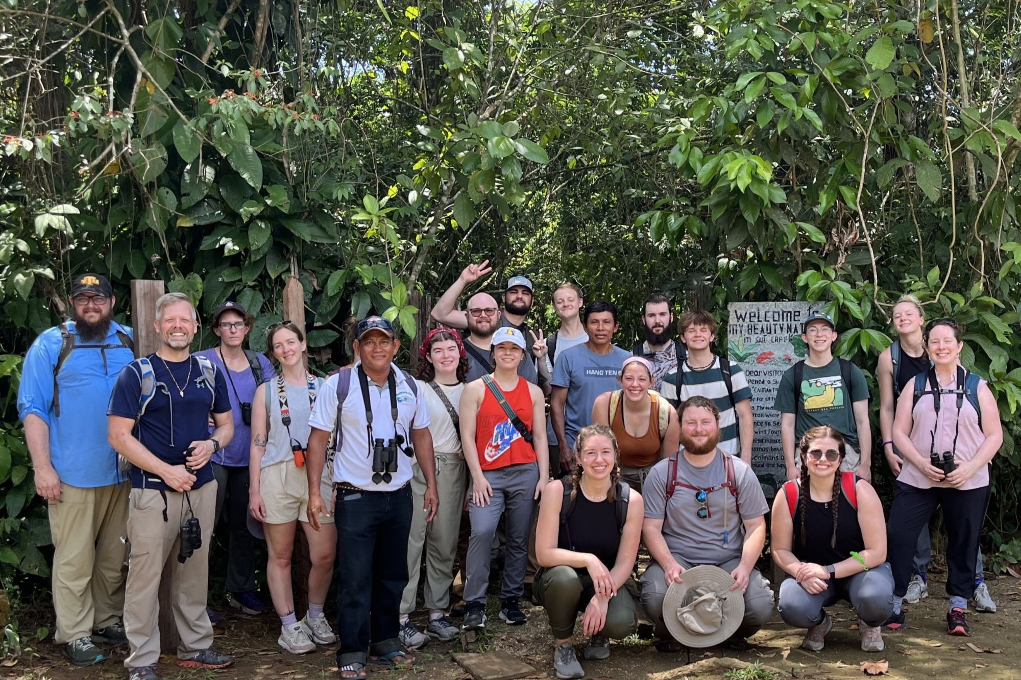 Group of faculty and students standing in front of rainforest in Panama.