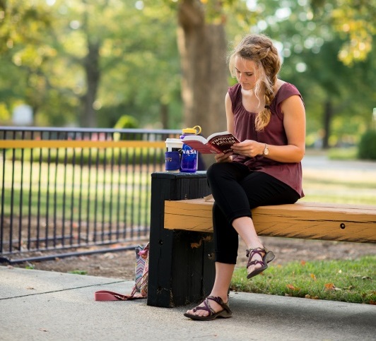 Girl reading on a bench.