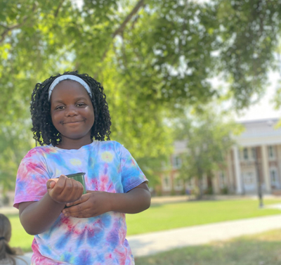 A smiling child experiencing a beautiful day on Tech's campus.