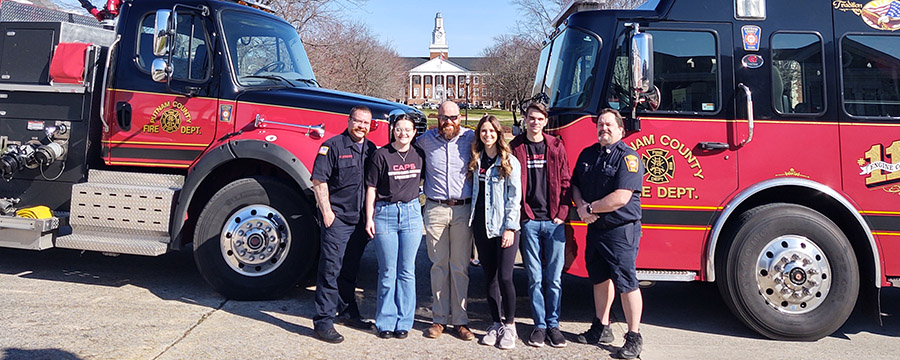 Dr. Derrick Edwards and team standing by fire trucks on at the end of the TN Tech Quad with Derryberry in the background.
