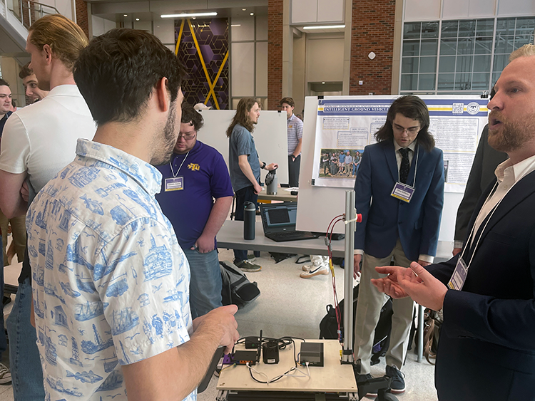 Mechanical engineering student showing project to industry partners