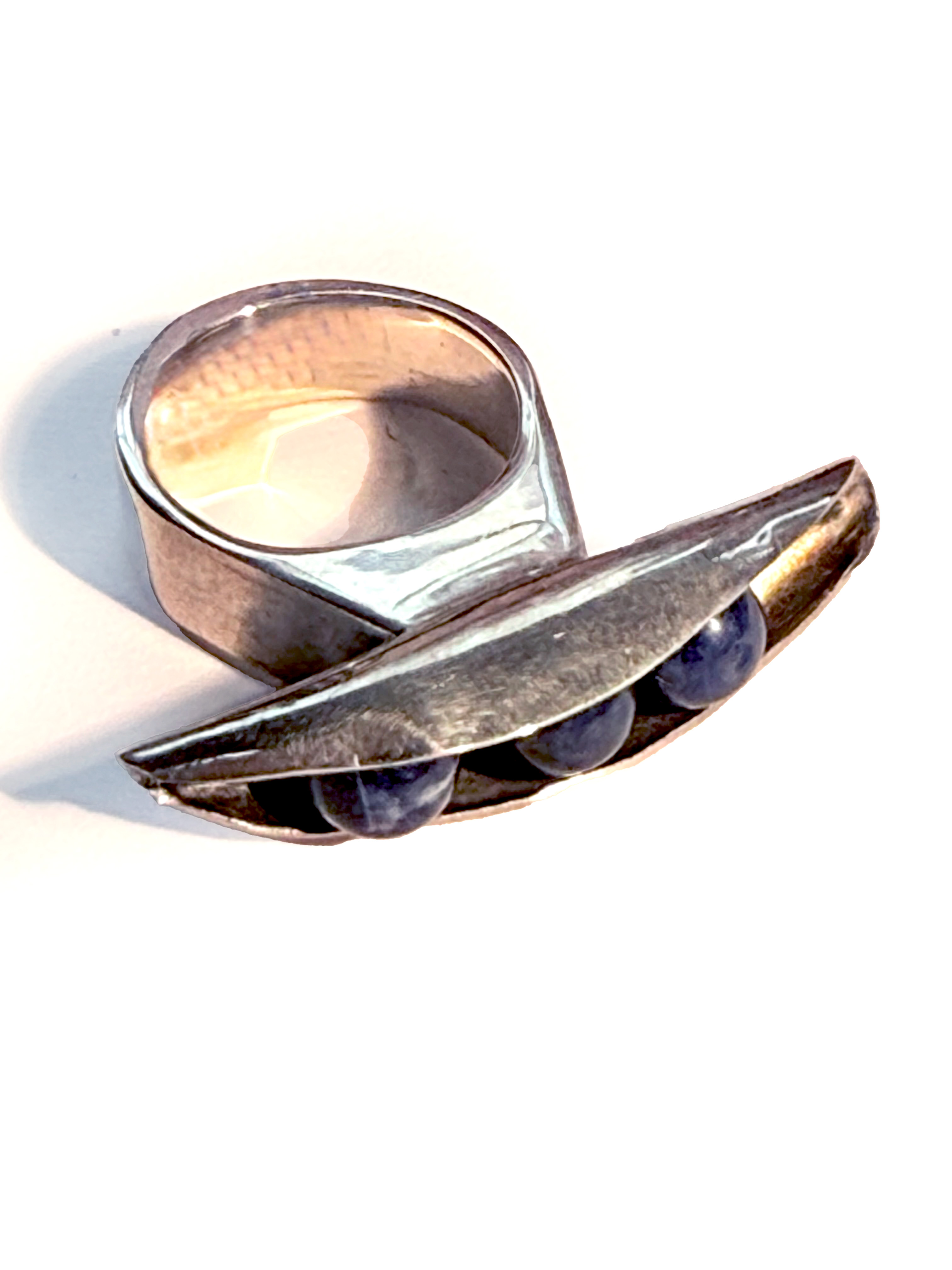 Silver ring with pea pod object on front of ring