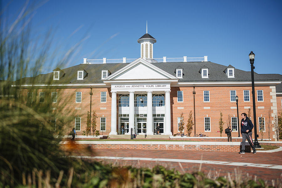 students walking in front of Volpe Library on a sunny day