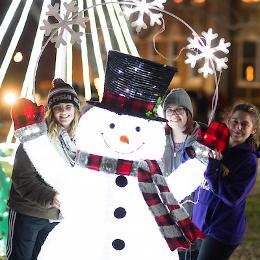 Friends posing with a lite up snowman decoration