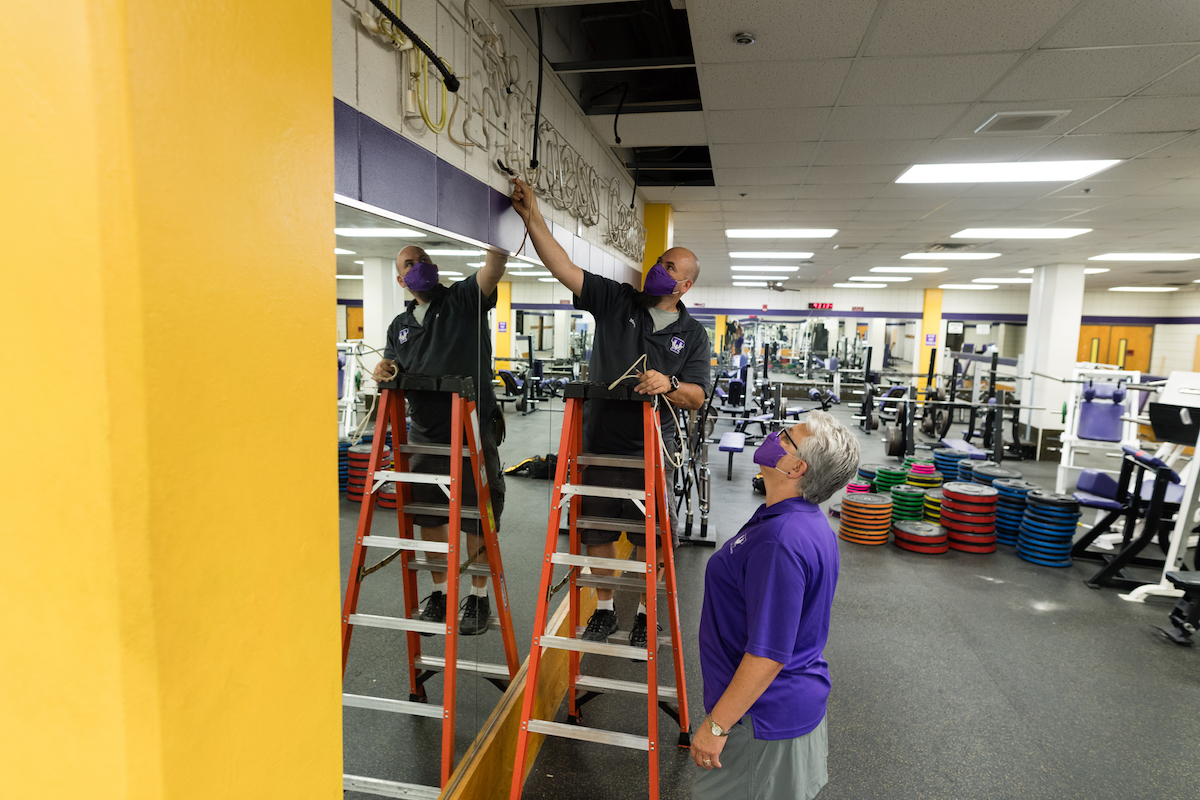 Christy Killman, chair of the exercise science department, and Marty Reeder, an electrician with campus facilities, work on renovating the old fitness center into the Academic Wellness Center.