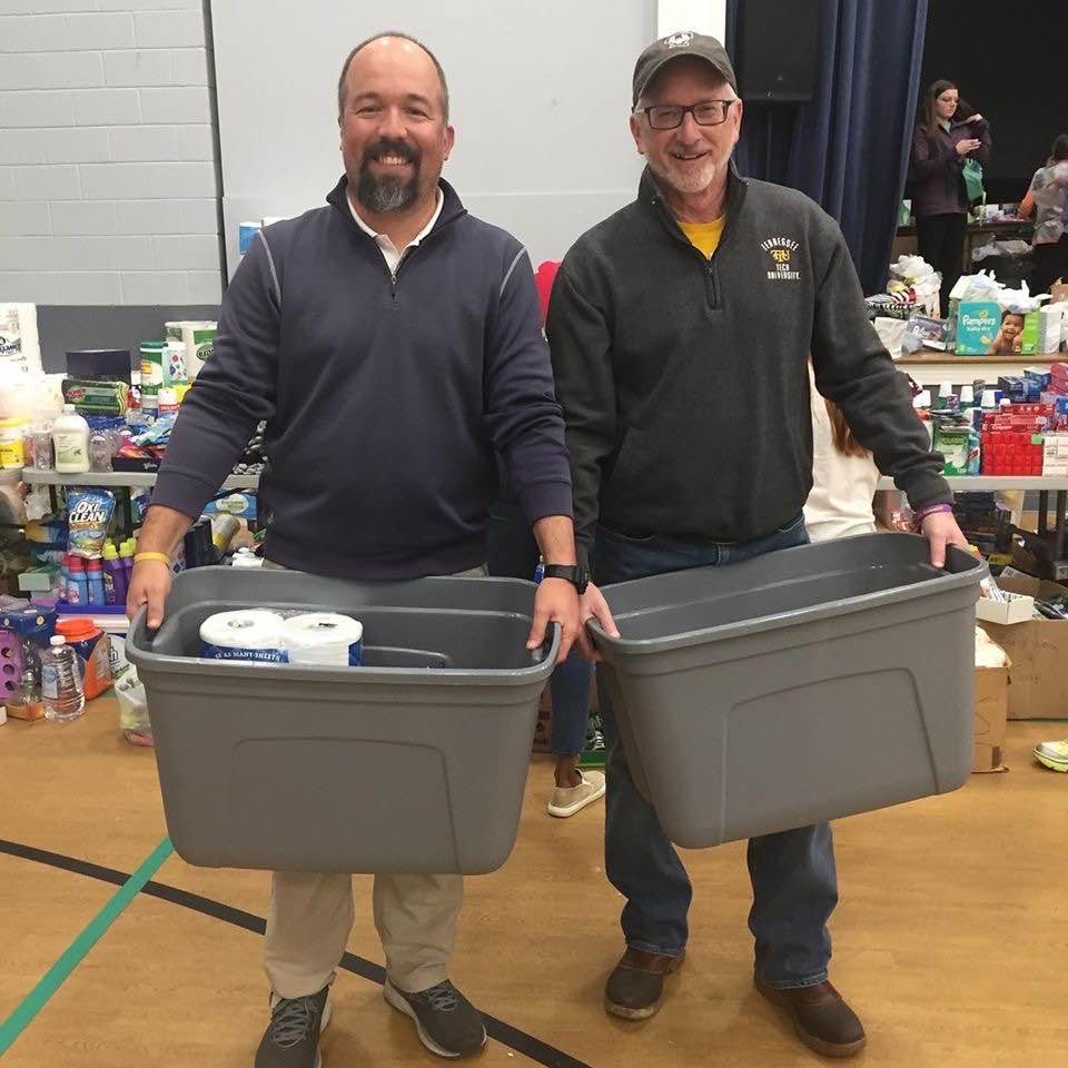 Tennessee Tech golf coach Polk Brown and President Phil Oldham help with donations at the Cookeville Community Center on Wednesday.