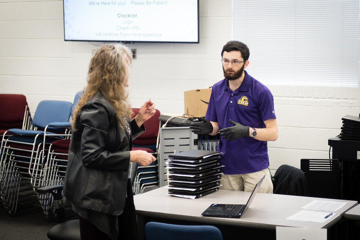 Tennessee Tech’s Information Technology Services handed out more than 180 laptop computers to faculty and staff on Wednesday to help with the campus going to online classes on Monday and assist with those who will be working from home. Janet Johnson, from the School of Art, Craft and Design, gets some help from Jacob Sweeten of ITS.
