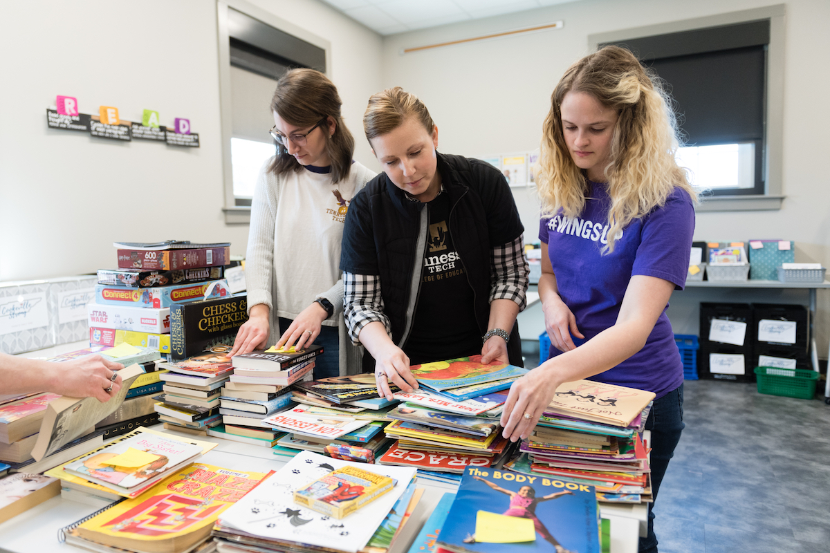 Going through some of the books, from left, are Lindsey Braisted, master’s student in the curriculum and instruction, Cookeville; Amanda Spears, assistant professor; and Cassie Schmitt-Matzen, PhD student in exceptional learning, Cookeville.