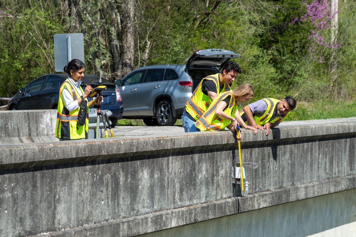 Tech students Maci Arms and Thomas Harris, along with civil and environmental engineering associate professor Alfred Kalyanapu check a sensor while civil and environmental engineering associate professor Tania Datta records the data on a bridge in Gainesboro.
