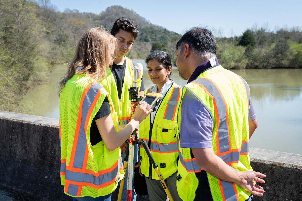 (From left) Tennessee Tech students Maci Arms and Thomas Harris along with Tania Datta and Alfred Kalyanapu, associate professors in civil and environmental engineering, look over data collected from sensors on a bridge in Gainesboro.