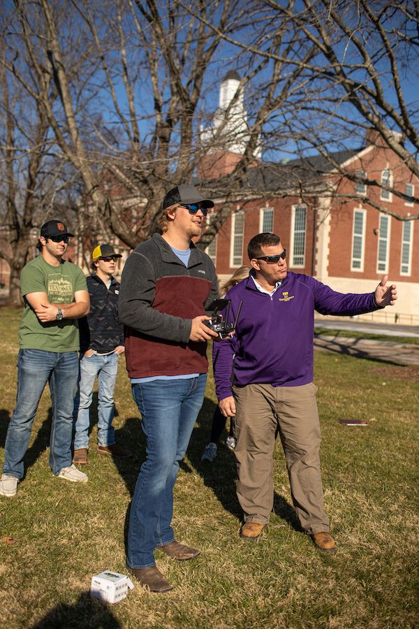 Nattrass guides a student in flying a drone around Tech's campus during a practice flight.