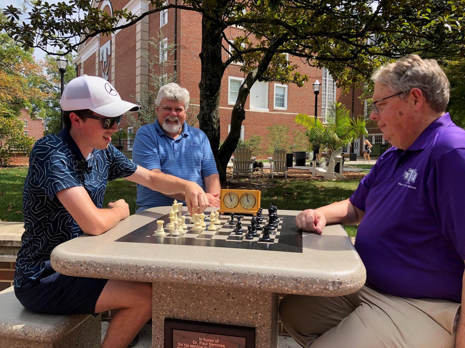  Tennessee Tech Chess Club President Austin Jerrolds, left, and retired Arts and Sciences Dean Paul Semmes, right, compete in a friendly match at the newly dedicated chess table outside Henderson Hall as Interim Dean Jeff Roberts provides encouragement. 