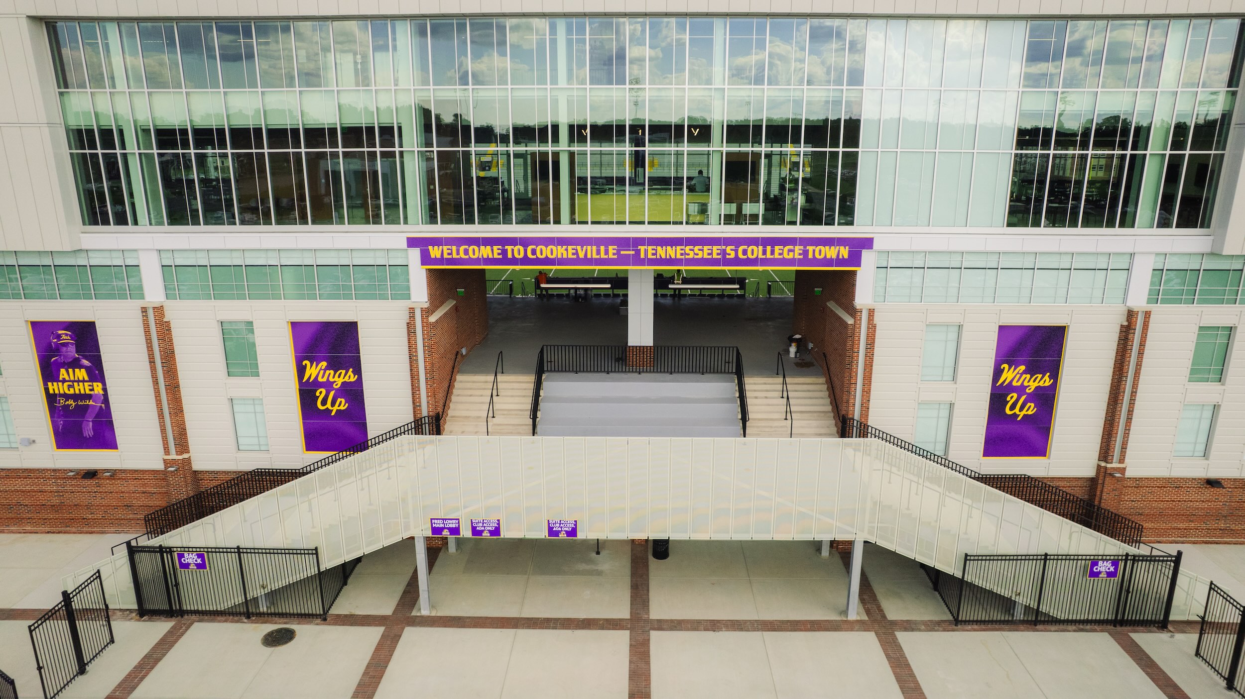 A view of the stadium's main entrance with purple and gold signage.