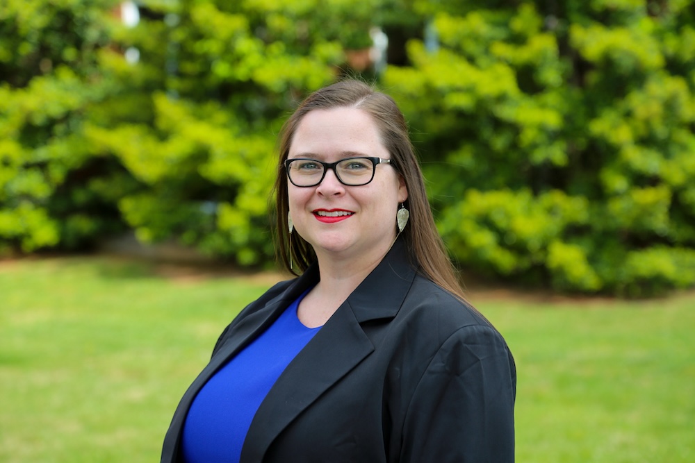 Headshot for Chelsea Dowell smiling in a blue blouse and dark blazer. 