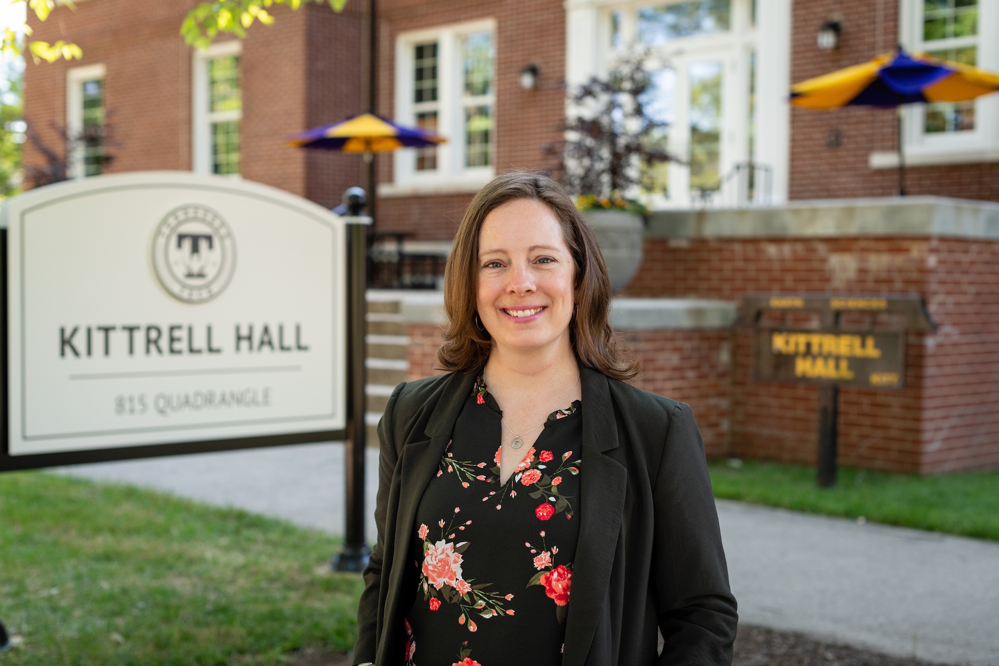 Jeannette Luna stands and smiles in front of Kittrell Hall.