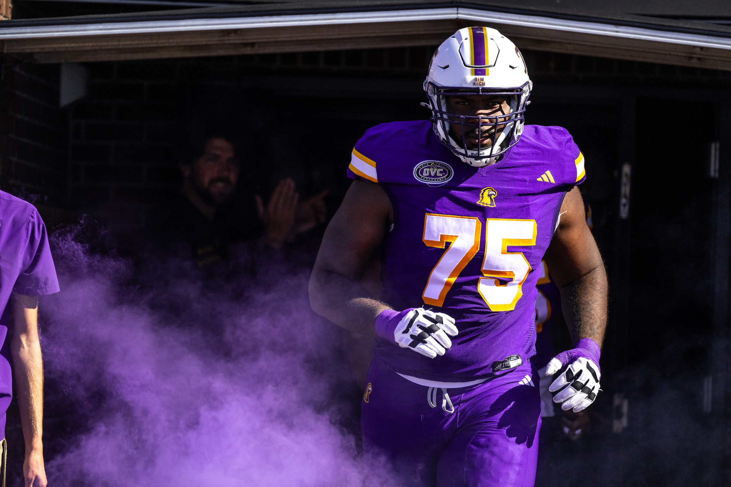 A Tennessee Tech football player emerges from the stadium tunnel on gameday shrouded in purple smoke