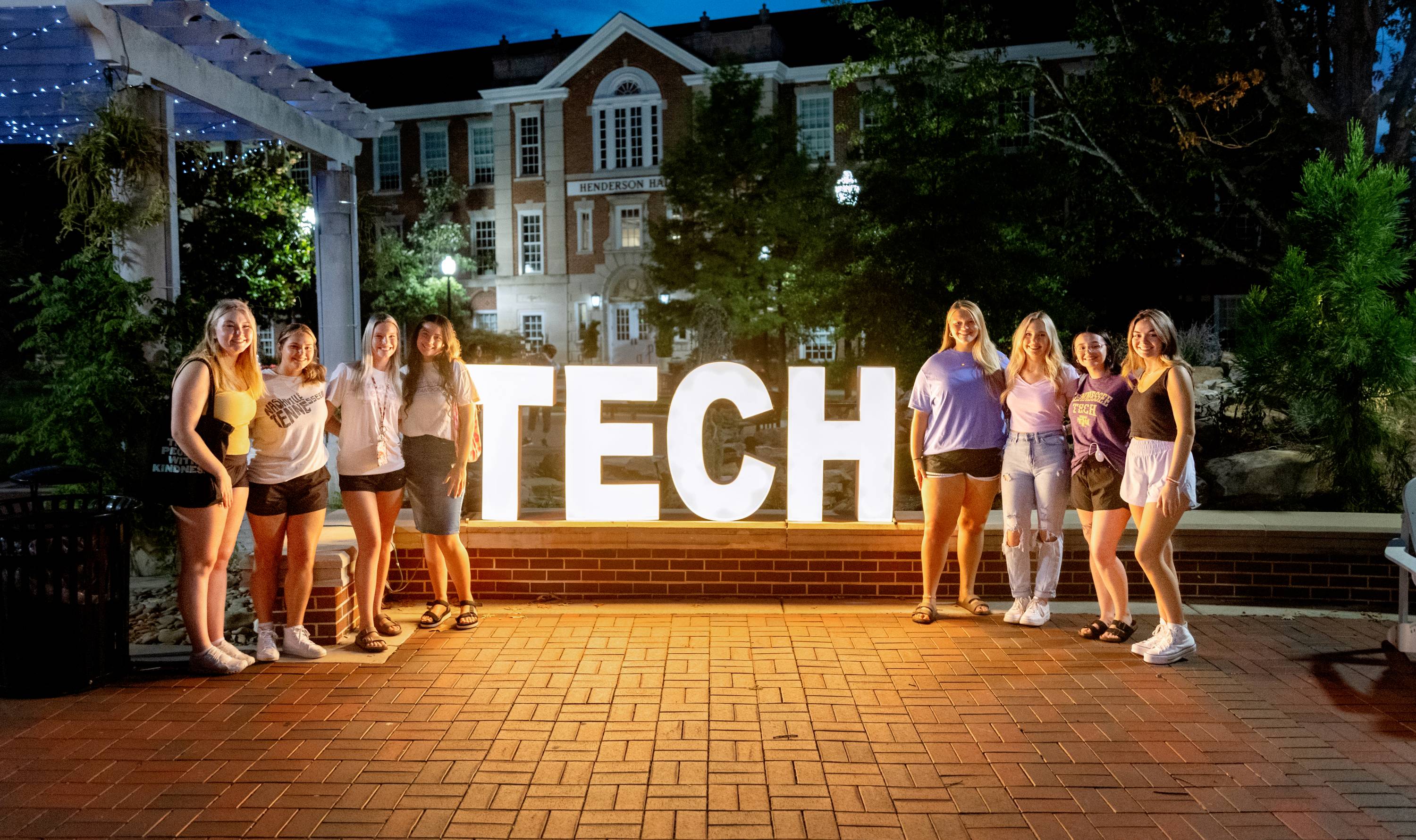 Students at Week of Welcome standing in front of a lit TECH sign.