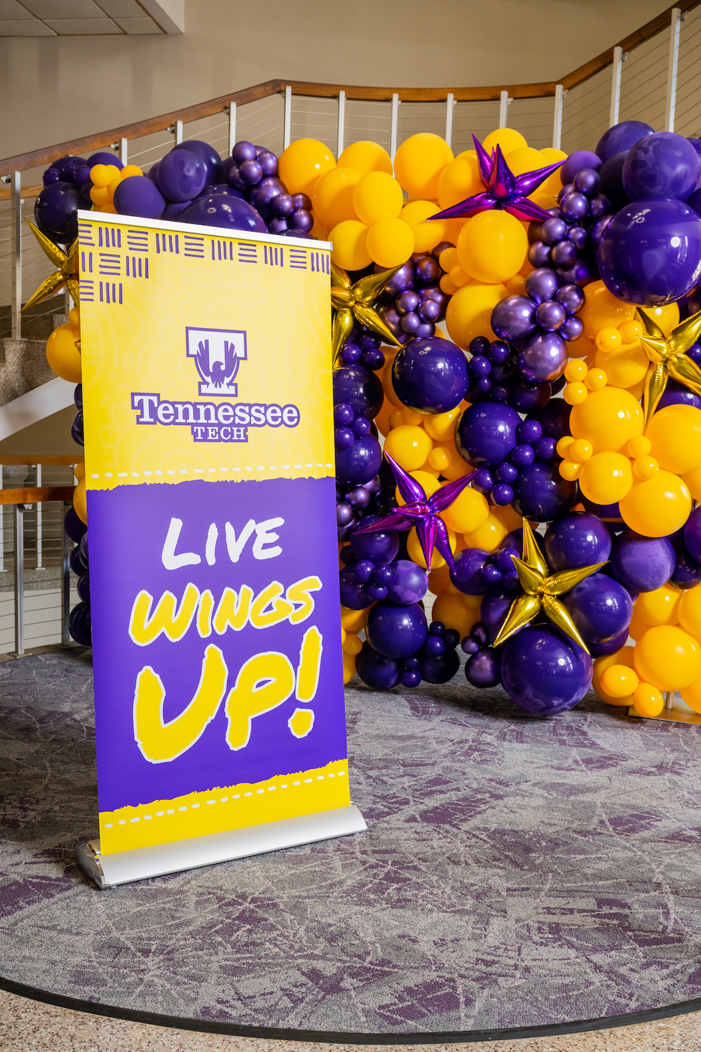 Tall banner that says "Tennessee Tech LIVE WINGS UP!" in front of baloon display
