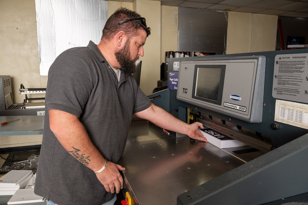 man working machine in printing services