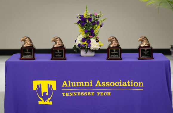 Alumni Awards (bronze eagle heads on wooden bases) on a table