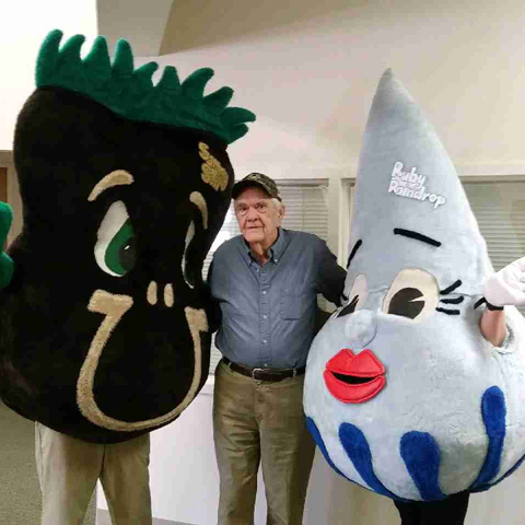Howard Whitaker poses with mascots of Sammy Soil and Ruby Raindrop.