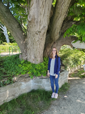 photo of assistant archivist Hanna O'Daniel McCallon standing next to a large tree