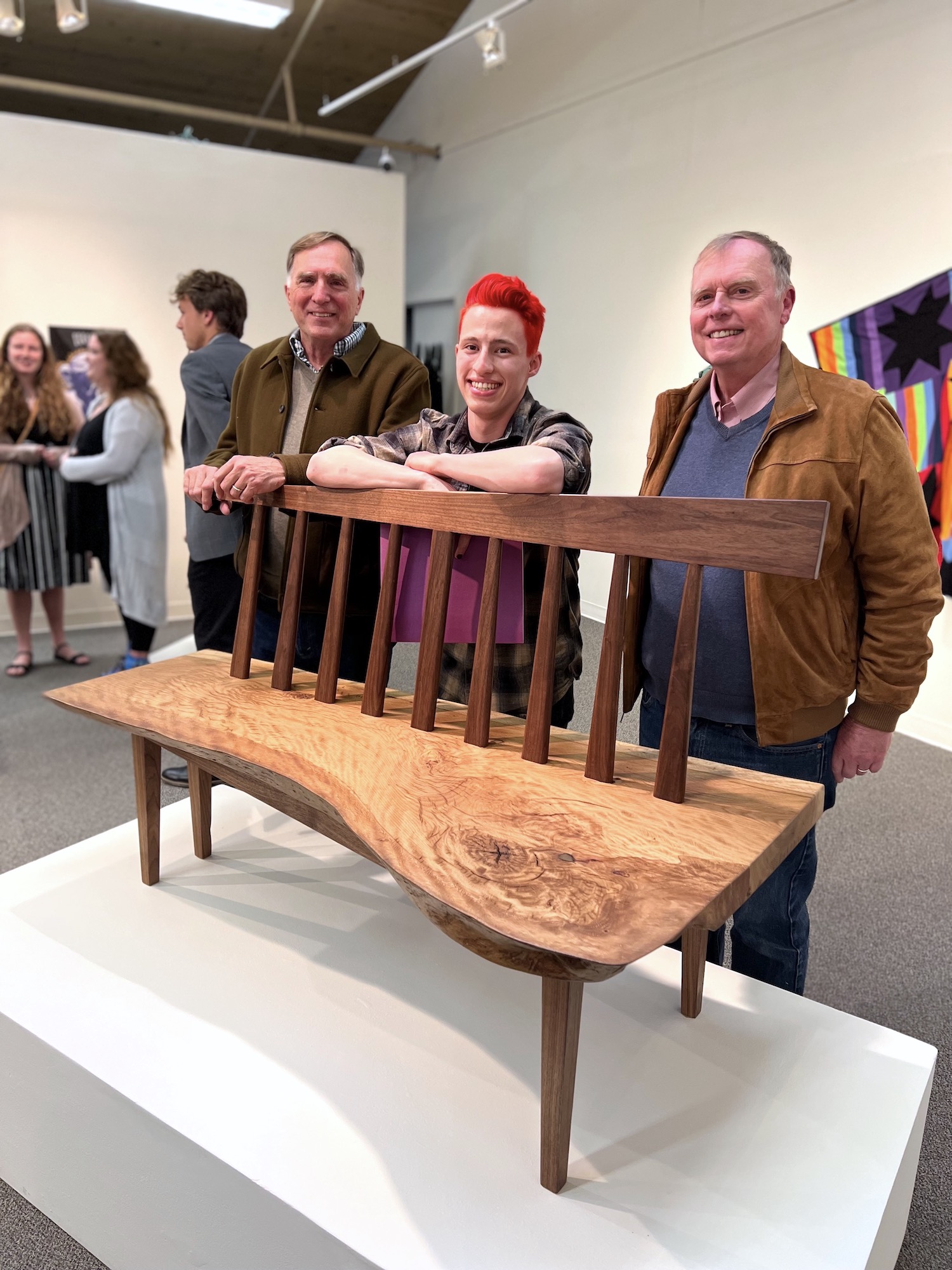Westfield and Magnuson stand with Grant Stewart behind his art piece - a wooden bench.