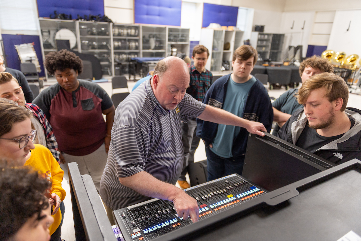 students watch a professor at a digital mixing board