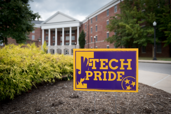 A Purple and Gold Tech Pride sign in front of New South Hall.