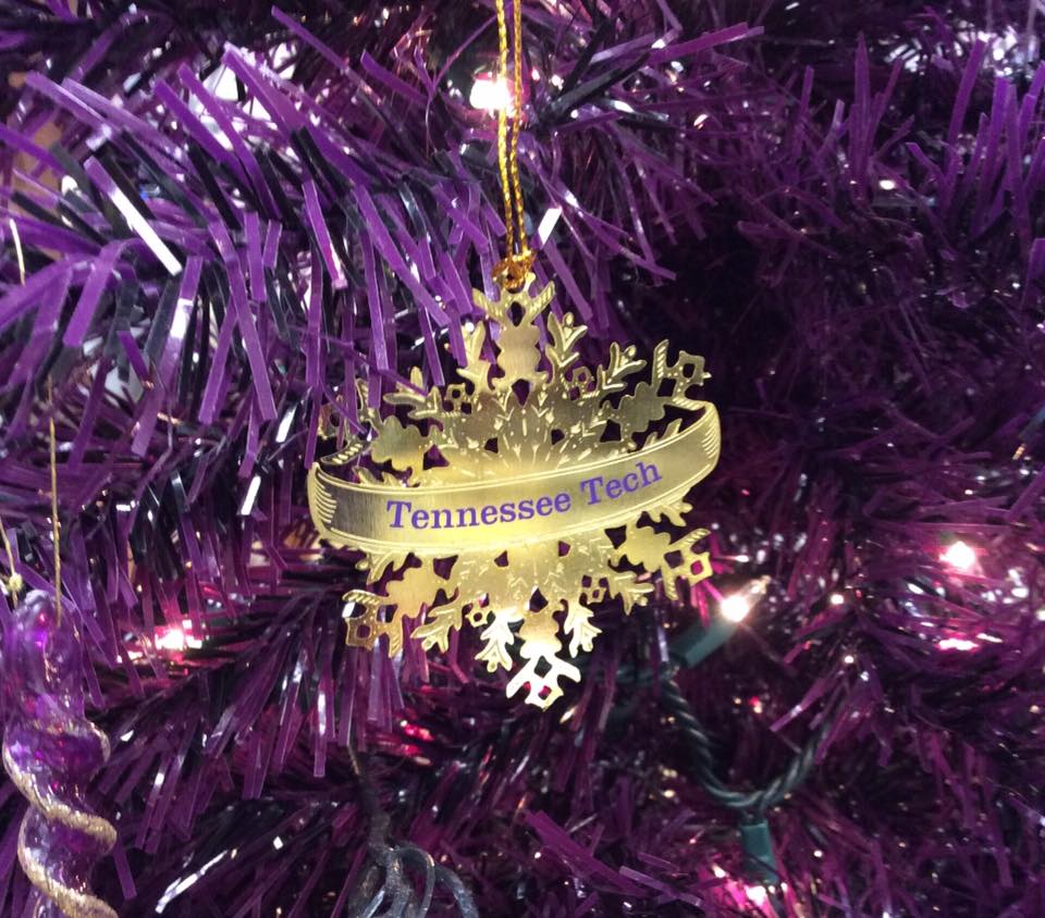 A golden Tennessee Tech ornament in the shape of a snowflake on a purple tinsel tree