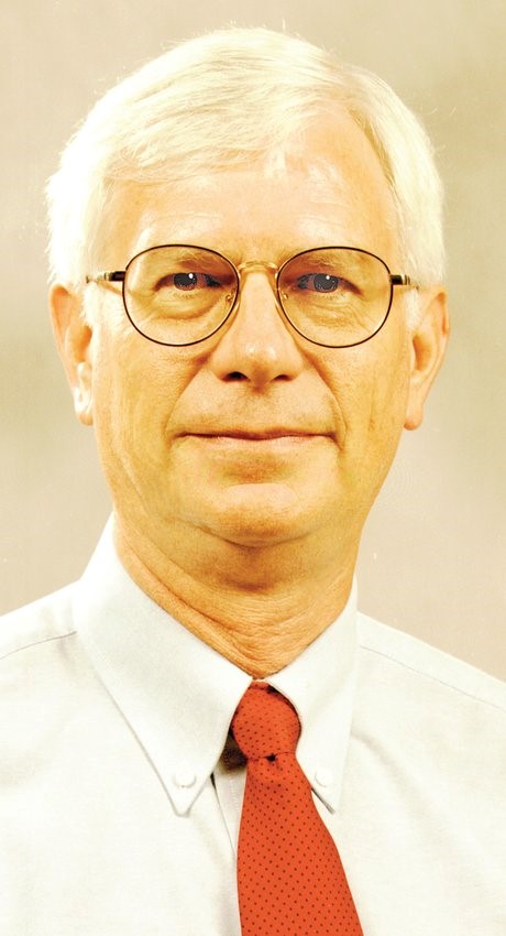 A photo of Calvin Dickinson in a dress shirt with a red tie.