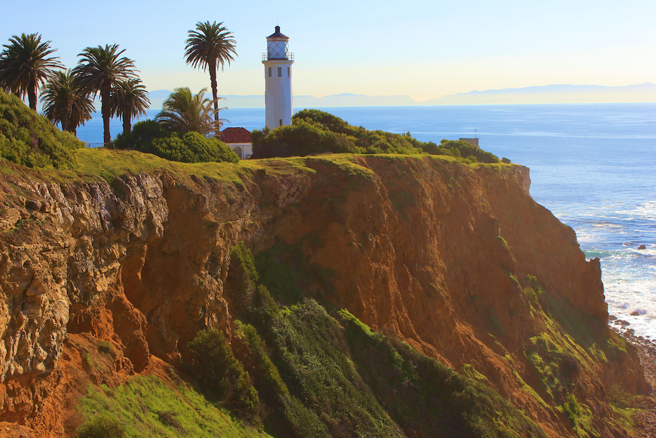 A light house on a cliff overlooking the Pacific Ocean.