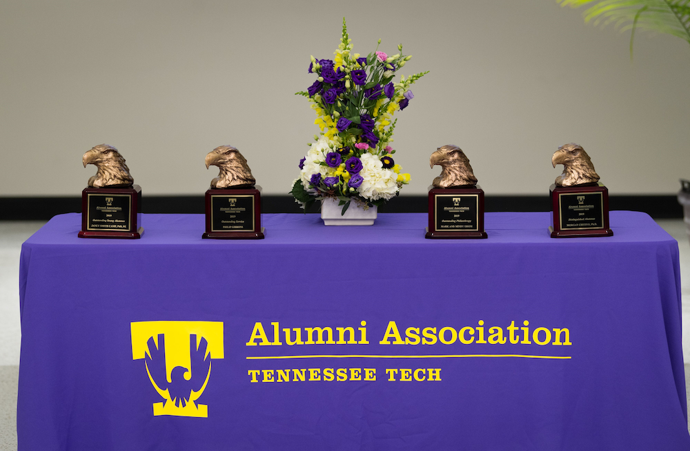 A table with flowers and golden eagle head awards