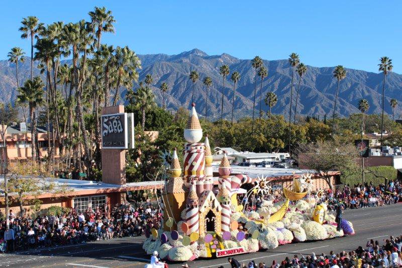 a float with palm trees and hills surrounding it at the tournament of roses parade