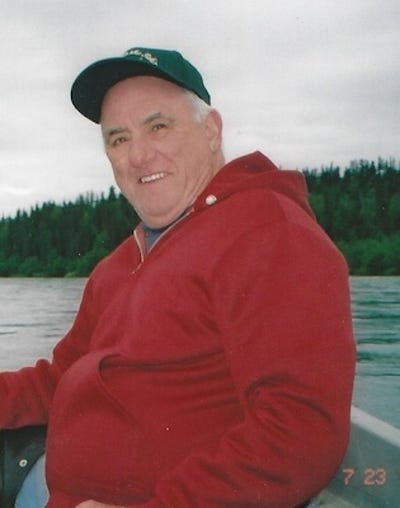 A portrait of Dennis Cebe in a red sweatshirt on his boat.