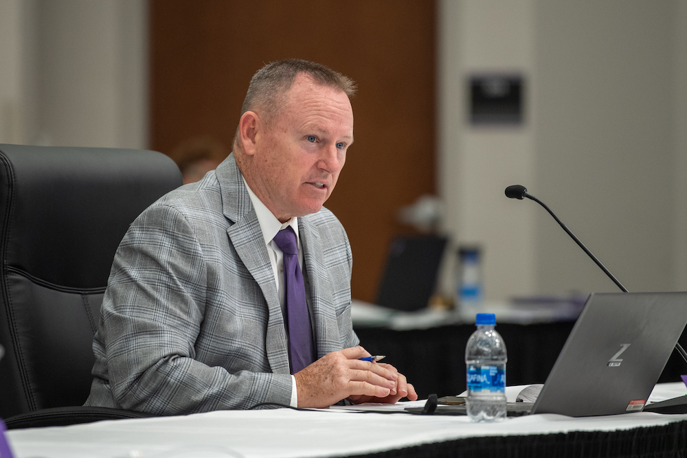 A photo of Barry Wilmore sitting at a board of trustees meeting.