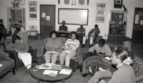 A black and white photo of students in the Leona Lusk Officer Black Cultural Center.