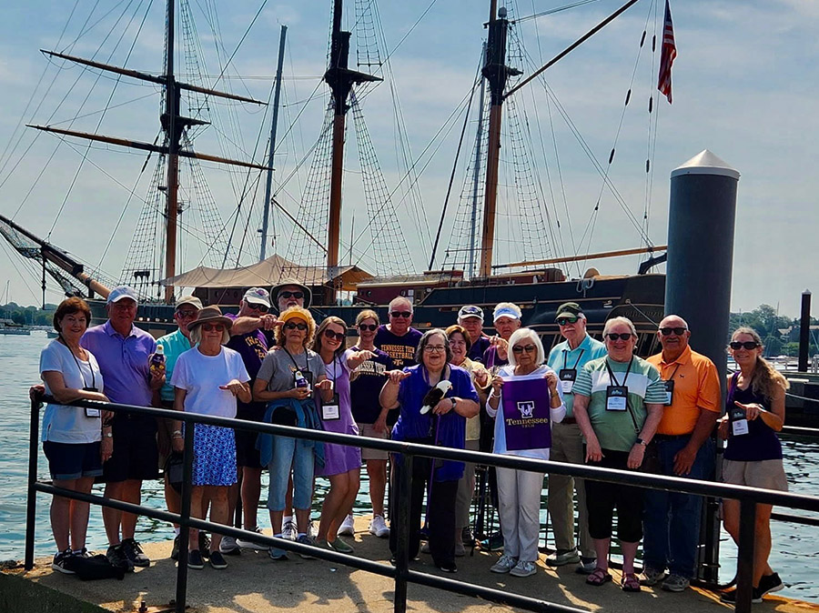 The Alumni group that went on the trip posing for the camera on a dock. 