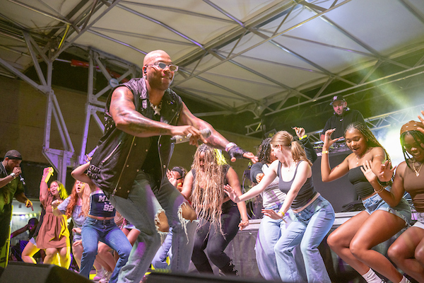 A groupd of students standing on stage with the host of the event. 