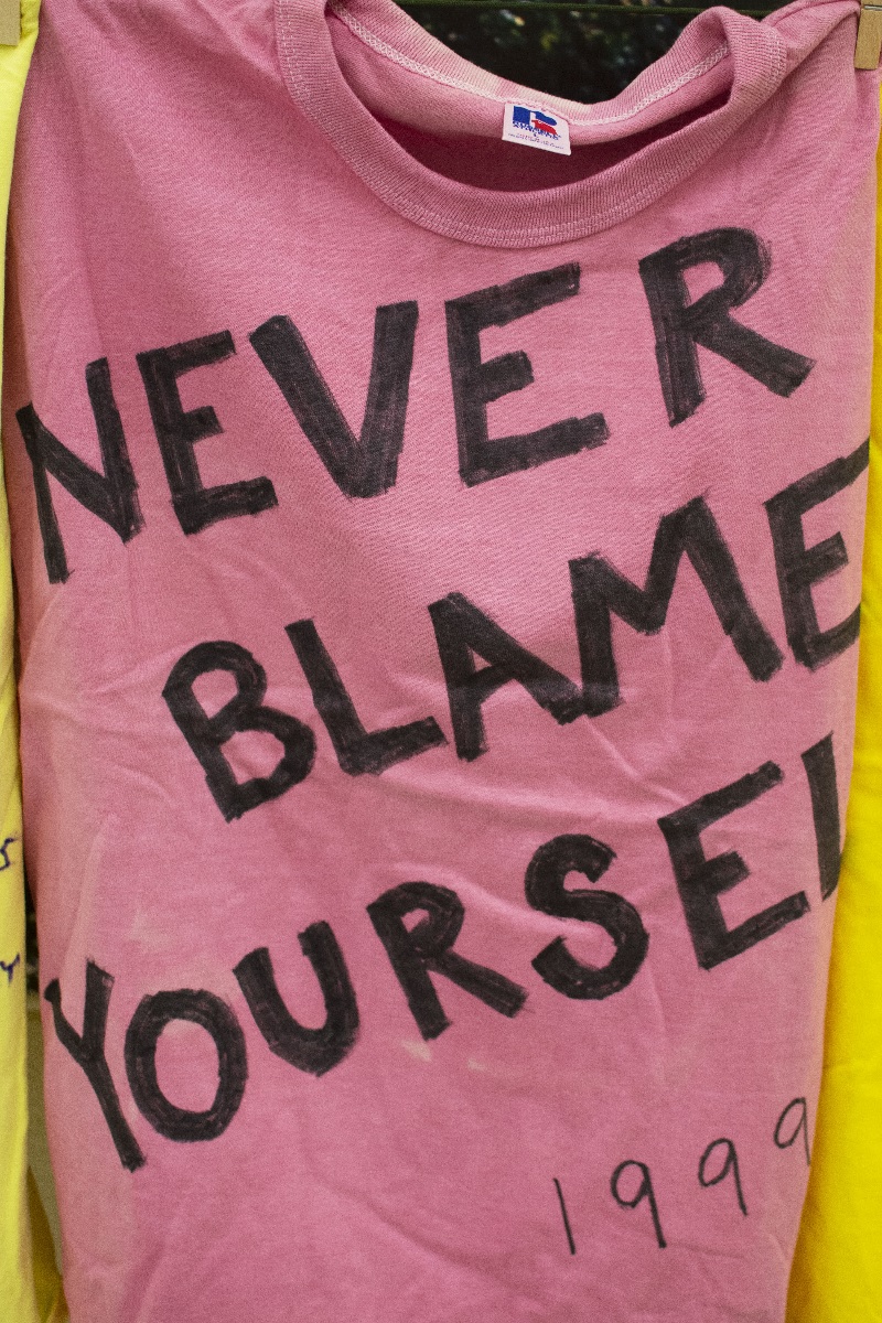 A tshirt on the clothesline saying Never Blame Yourself 1999